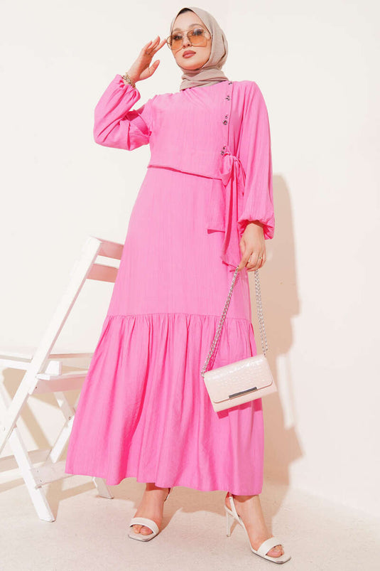 فستان وردي بربطة عنق وتفاصيل فتحات