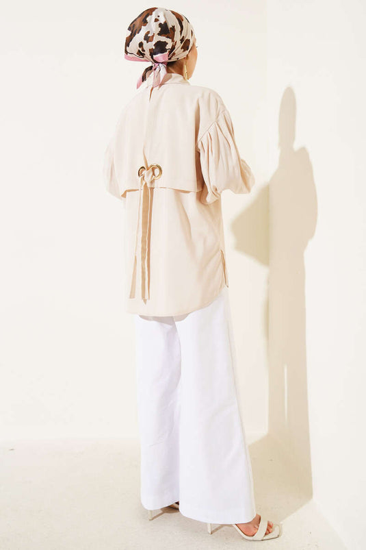 قميص بأكمام منفوخة وتفاصيل فتحات صغيرة باللون البيج