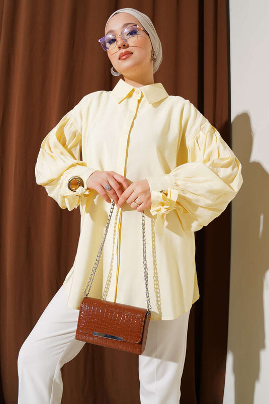 قميص أصفر بأكمام منفوخة وتفاصيل فتحات