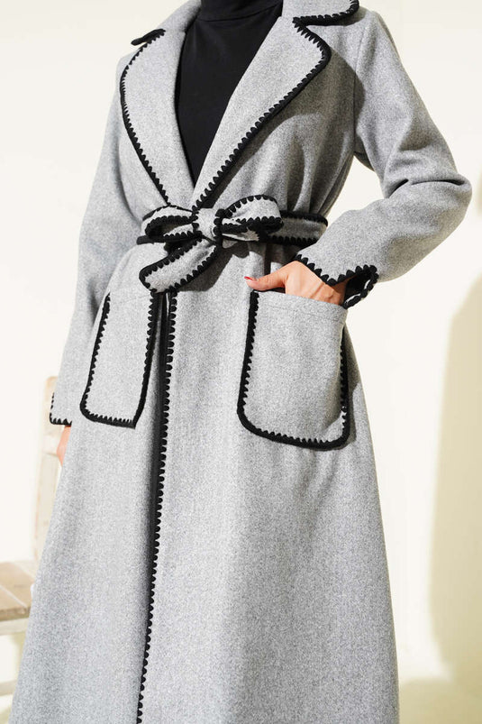 معطف كشمير رمادي اللون مزين بتطريزات على شكل صدفة وحزام