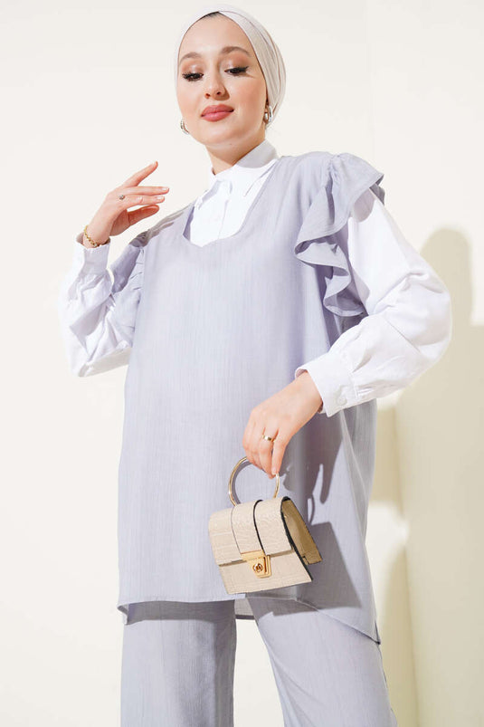 بدلة رمادية مكونة من ثلاث قطع مع سترة مكشكشة على الكتف