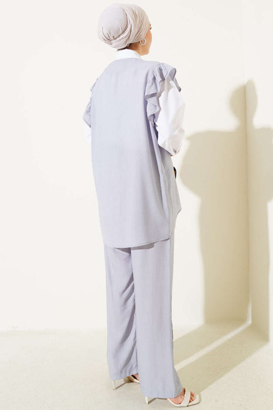 بدلة رمادية مكونة من ثلاث قطع مع سترة مكشكشة على الكتف