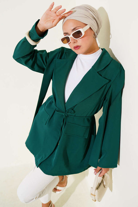سترة مربوطة بحبل ومطوية على الكتف باللون الزمردي