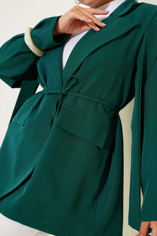 سترة مربوطة بحبل ومطوية على الكتف باللون الزمردي