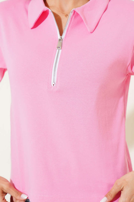 Roze T-shirt met schoudervullingen en ritssluiting.