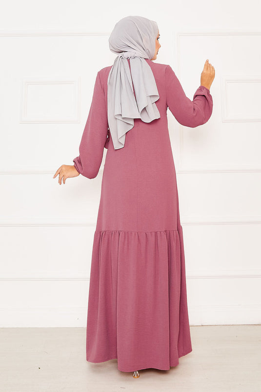 فستان وردي اللون بربطة عنق مع تفاصيل من الحساسية والحجر في الأمام