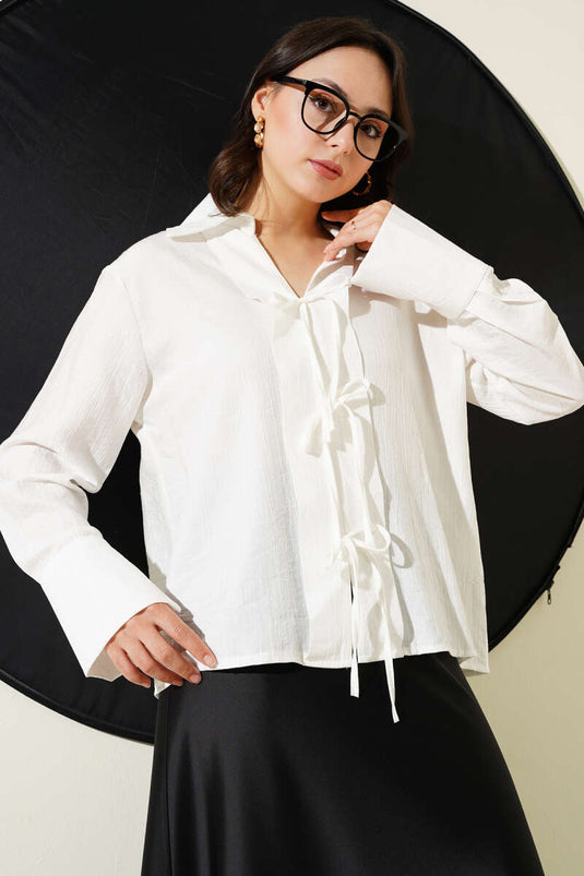 بلوزة بيضاء مع تفاصيل دانتيل في الأمام