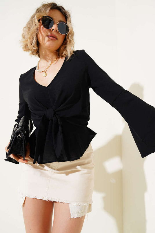 Chemisier noir à col en V et nœud sur le devant