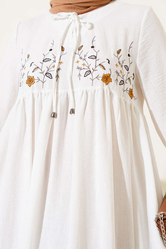 فستان أبيض مع تطريز زهري على الجهة الأمامية