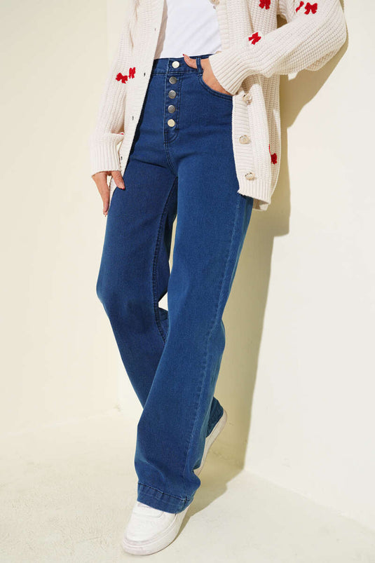 Jean en denim bleu à jambes larges avec boutons métalliques sur le devant.