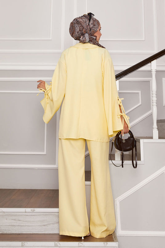 بدلة مكونة من قطعتين بتفاصيل دانتيل في الأمام والأكمام باللون الأصفر