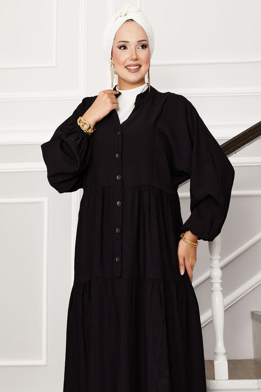 Robe noire à demi-boutons superposés sur le devant
