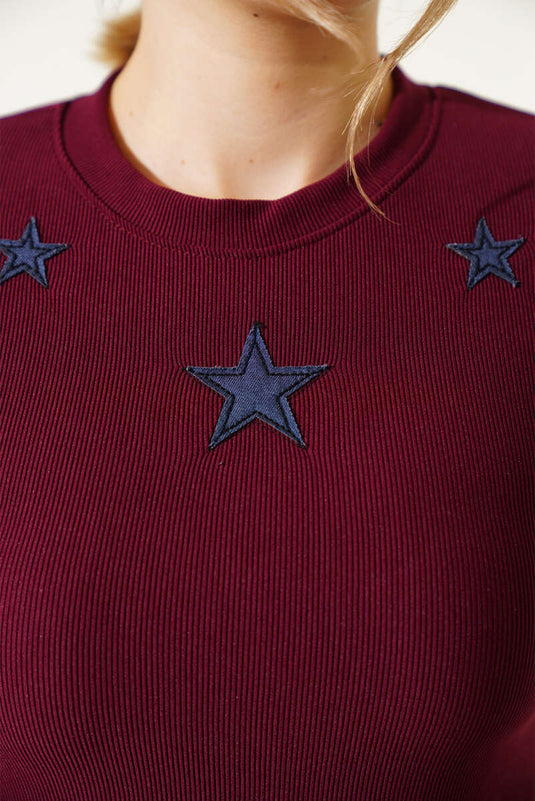 فستان قصير باللون العنابي مع نقشة نجمة على الجهة الأمامية