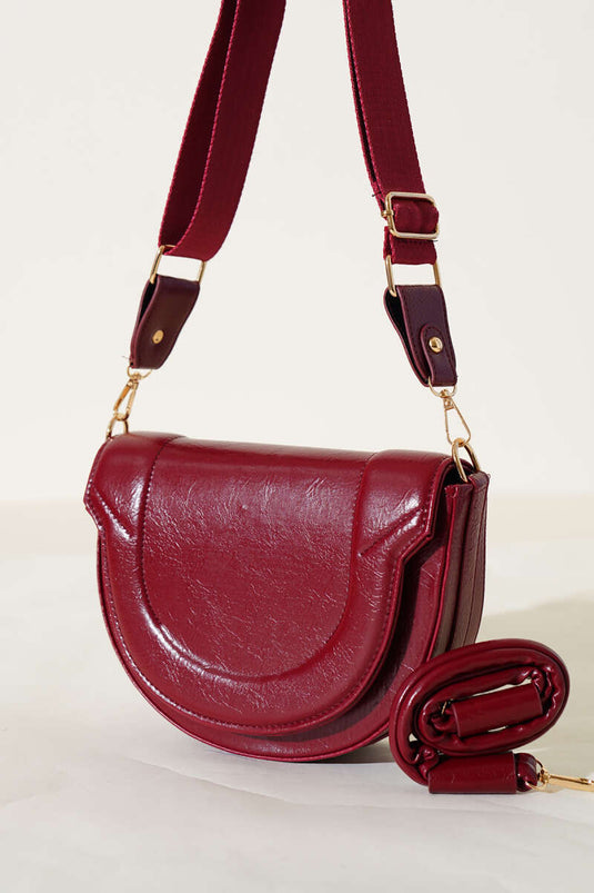 حقيبة بتفاصيل خياطة بيضاوية باللون العنابي