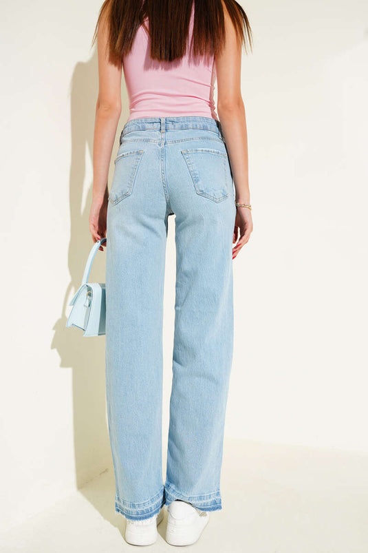 Vaqueros de mezclilla azul claro con detalle de borlas en el dobladillo