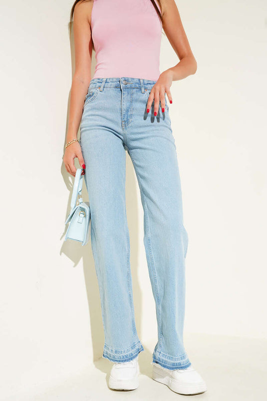 Vaqueros de mezclilla azul claro con detalle de borlas en el dobladillo