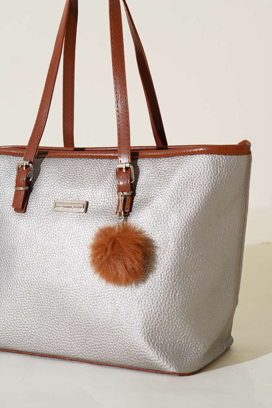 Silberne Schultertasche mit Pompon-Accessoire