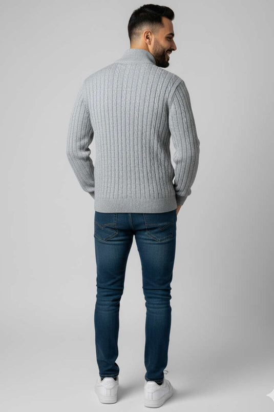 Suéter de punto gris con detalle de punto cable y cierre de cremallera.