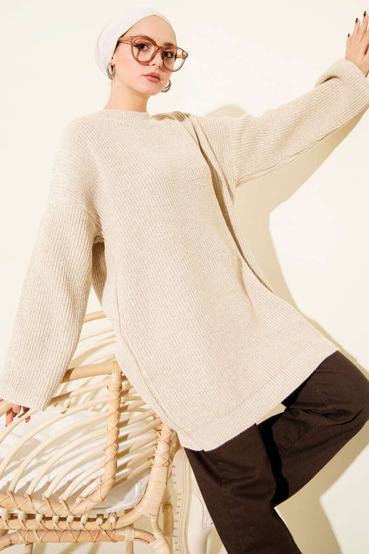 Tunica ampia in maglia scintillante color beige con scollo rotondo.