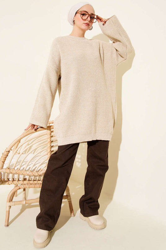 سترة طويلة فضفاضة برقبة دائرية لامعة محبوكة باللون البيج.