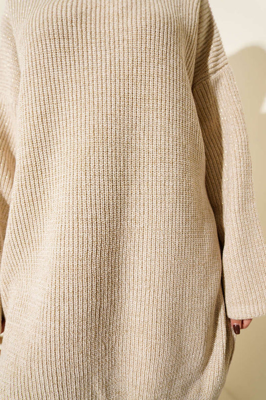 Tunica ampia in maglia scintillante color beige con scollo rotondo.