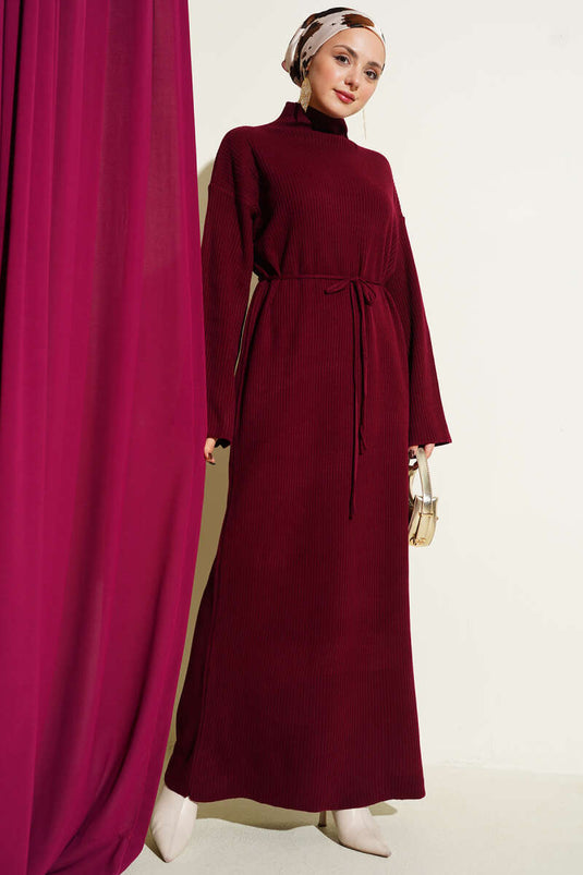 Robe ample en maille bordeaux avec ceinture.