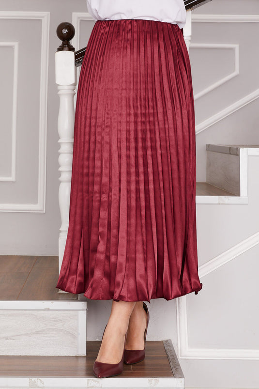 تنورة مطوية من الساتان باللون الأحمر الداكن