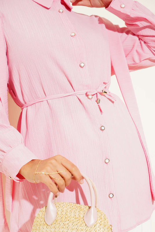 قميص وردي اللون بكتفين مطويين وأزرار حجرية