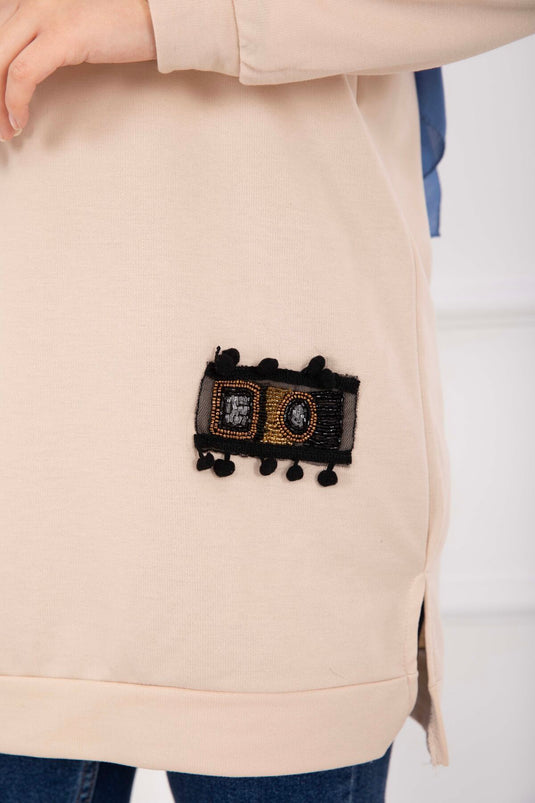 تونيك محتشم مزخرف بنقوش حجرية مع كرات صغيرة بلون بيج