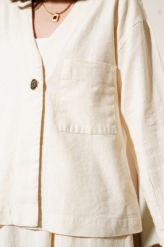 بدلة من قطعتين بجيوب وأزرار وتنورة باللون البيج