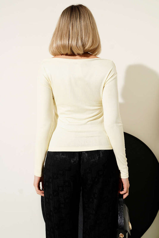 بلوزة صفراء بأكمام طويلة وياقة قارب.