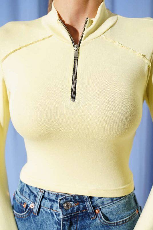 Long-sleeved half-zip blouse in lime color.
