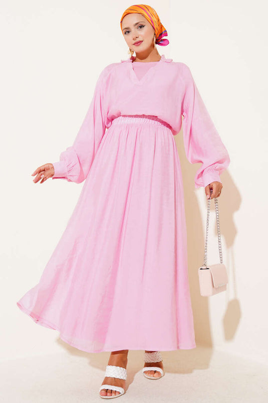 Ensemble trois pièces rose avec jupe à volants et col en V