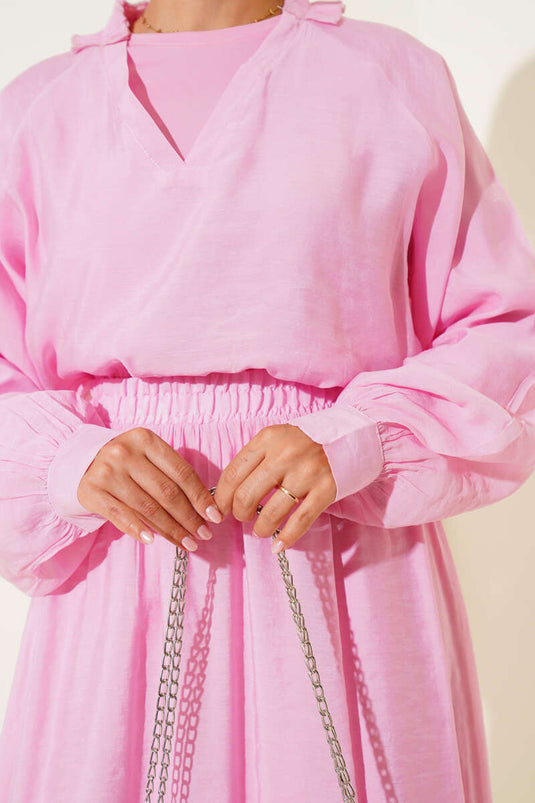 Ensemble trois pièces rose avec jupe à volants et col en V