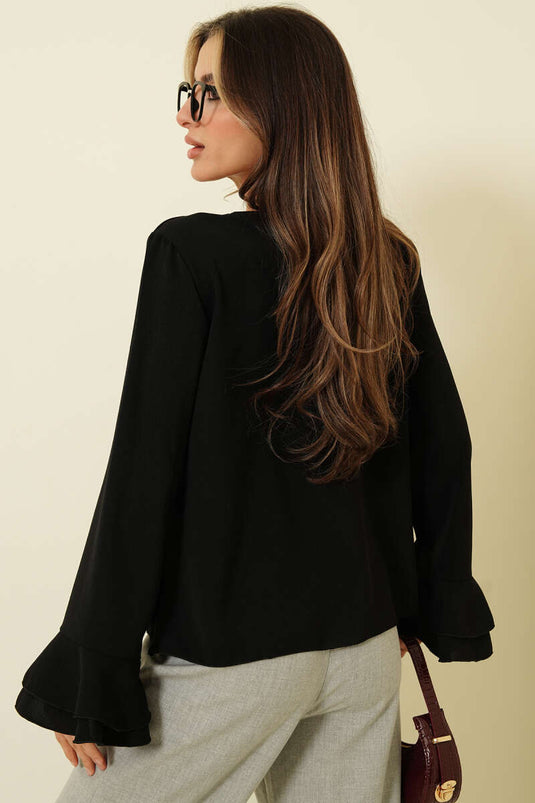 بلوزة بأكمام مكشكشة وتفاصيل كشكش باللون الأسود
