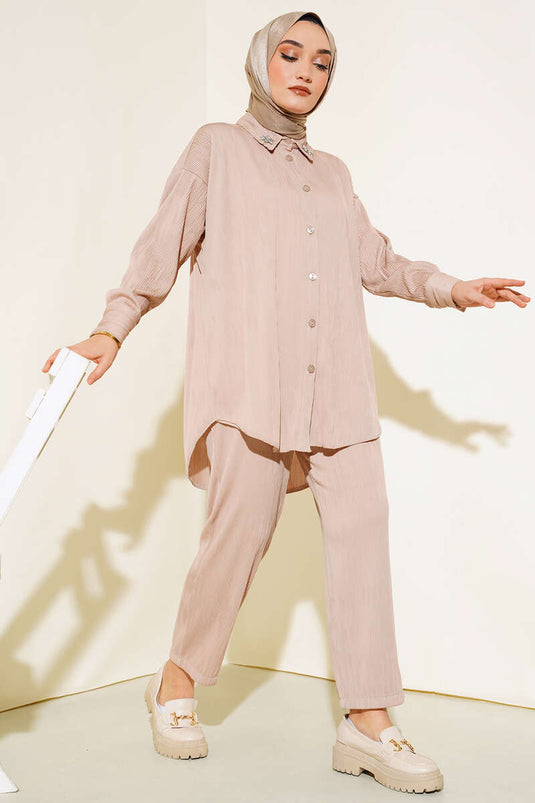 Costume beige à col fleuri et pierre