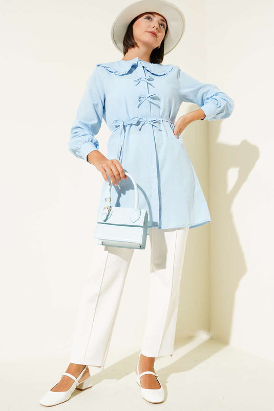 Tuniek met ruchekraag en strik in ijsblauw