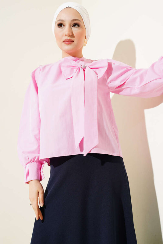 بلوزة وردية اللون مع طوق وإكسسوارات فيونكة