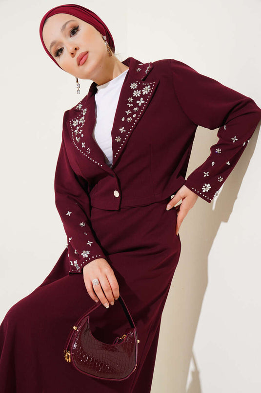 Tweedelig setje met versierde kraag, mouwen en rok in bordeauxrood.