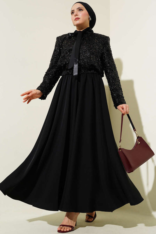 Met pailletten versierd tweedelig pak met kraag en lint, zwart