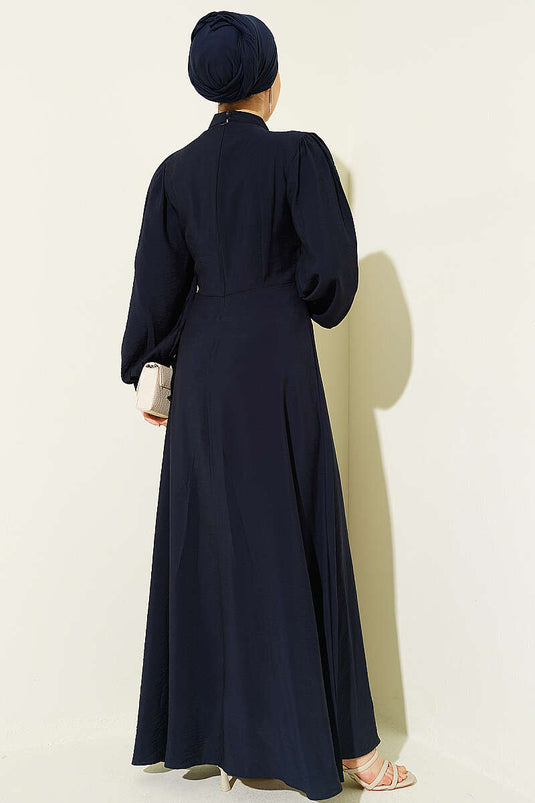 Robe bleu marine avec accessoire doré et nouée sur le côté