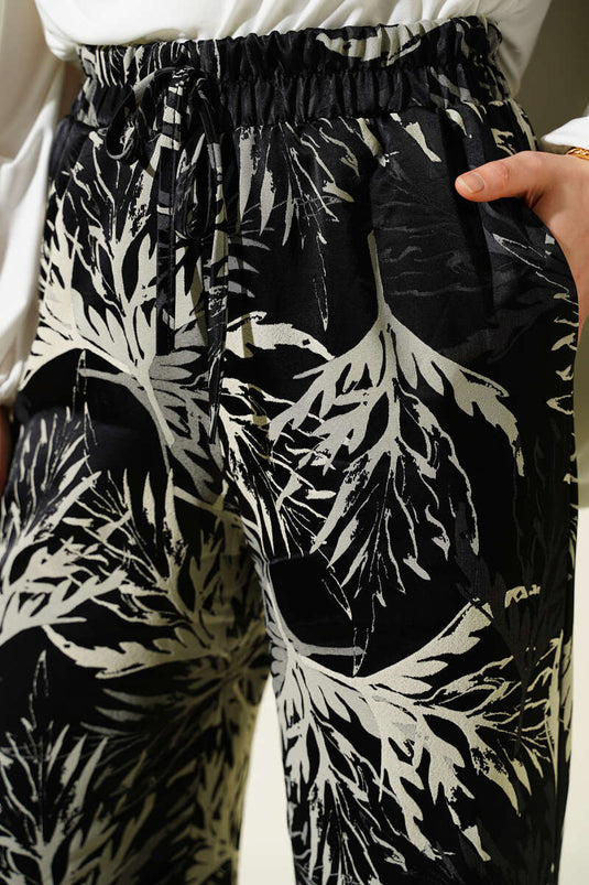 Pantalon large en satin à motif feuille noir