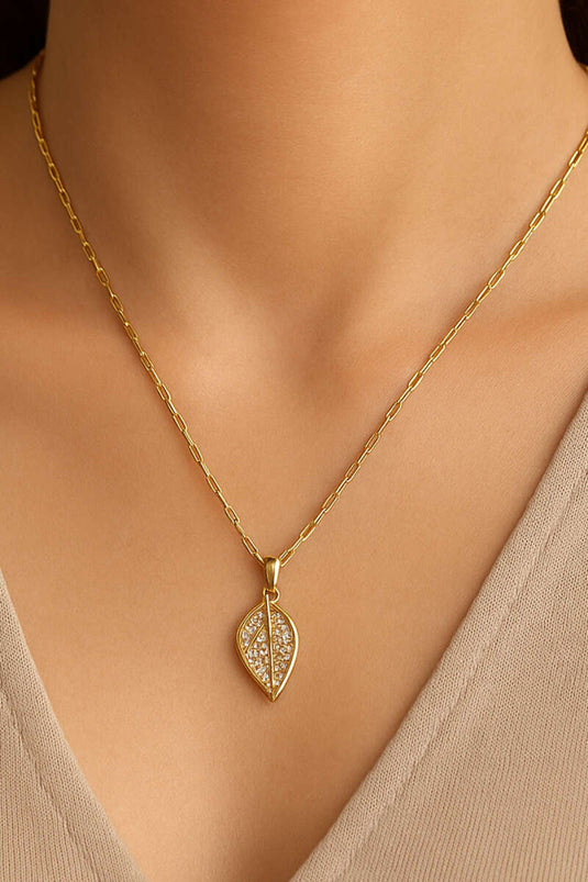 Gouden ketting met edelstenen in bladpatroon.