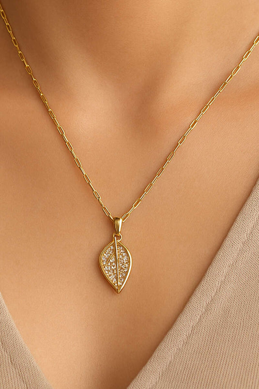 Gouden ketting met edelstenen in bladpatroon.