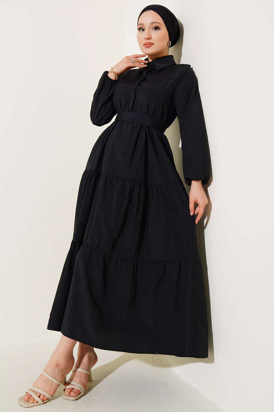 Schwarzes, halbgeknöpftes, tailliertes Lagenkleid mit Gürtel.