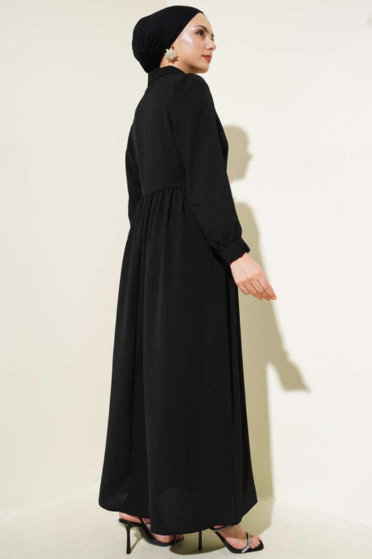 فستان أسود برباط جانبي وأزرار نصف حجر