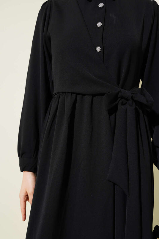 فستان أسود برباط جانبي وأزرار نصف حجر