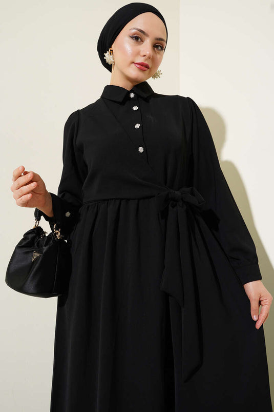 فستان أسود برباط جانبي وأزرار نصف حجر