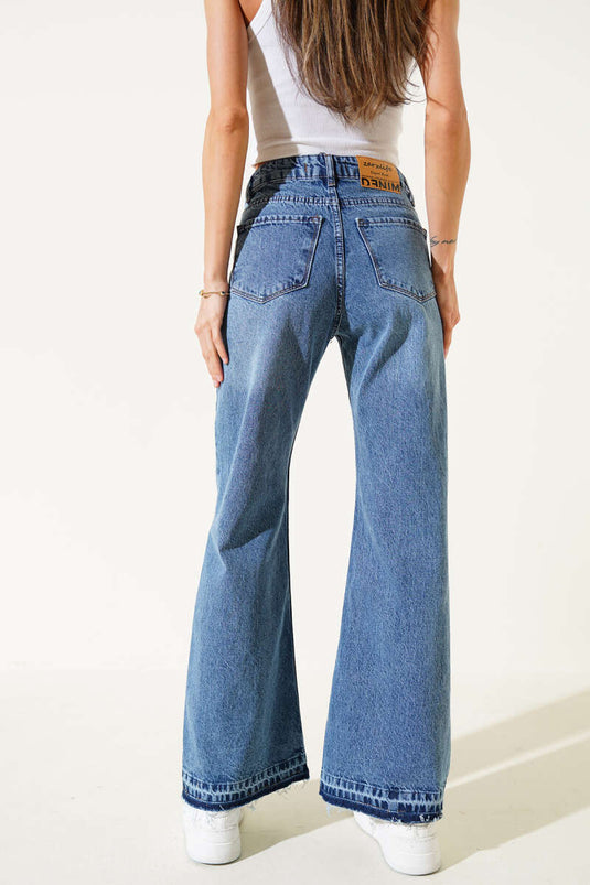 بنطال جينز أزرق بقصة جرس وتفاصيل ممزقة