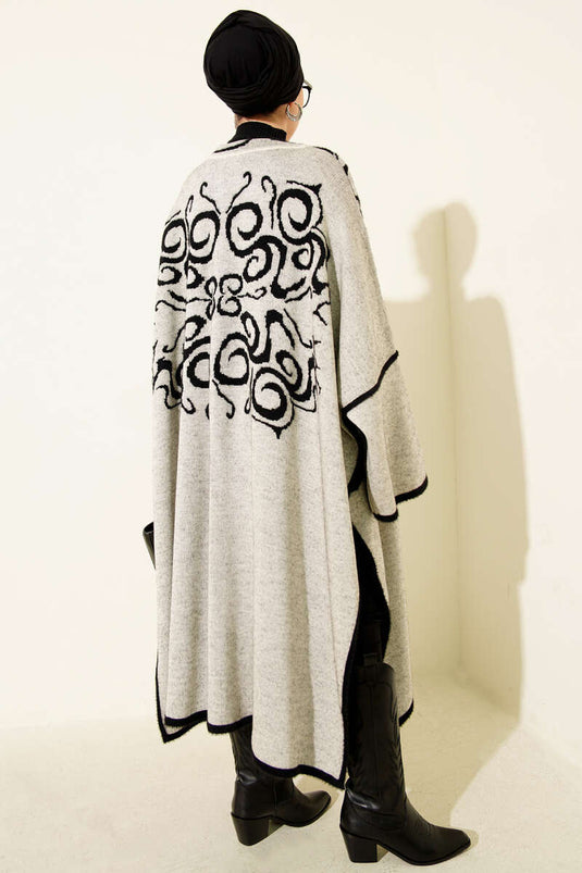 Poncho en angora noir et beige, col orné et boutons.